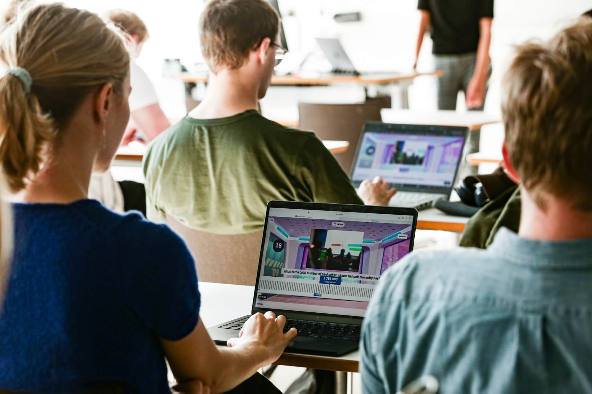 Higher ed students playing Kahoot! on laptops in a classroom