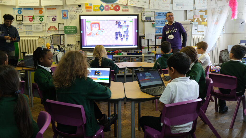 Teacher presenting Robot Run game mode to attentive class of students